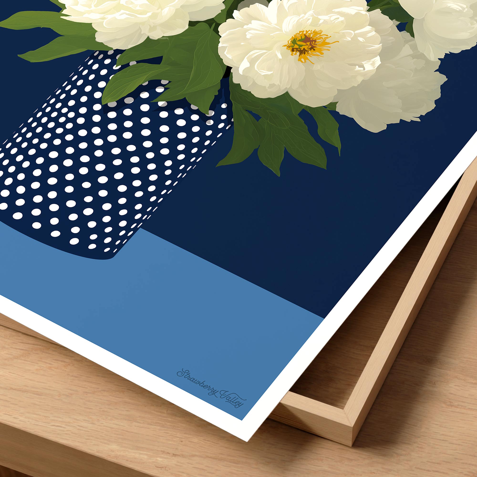 Navy blue poster with white polka dot border and white flowers on a wooden surface