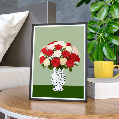 Framed artwork of a bouquet of red, white, and pink roses in a polka dot vase on a table.