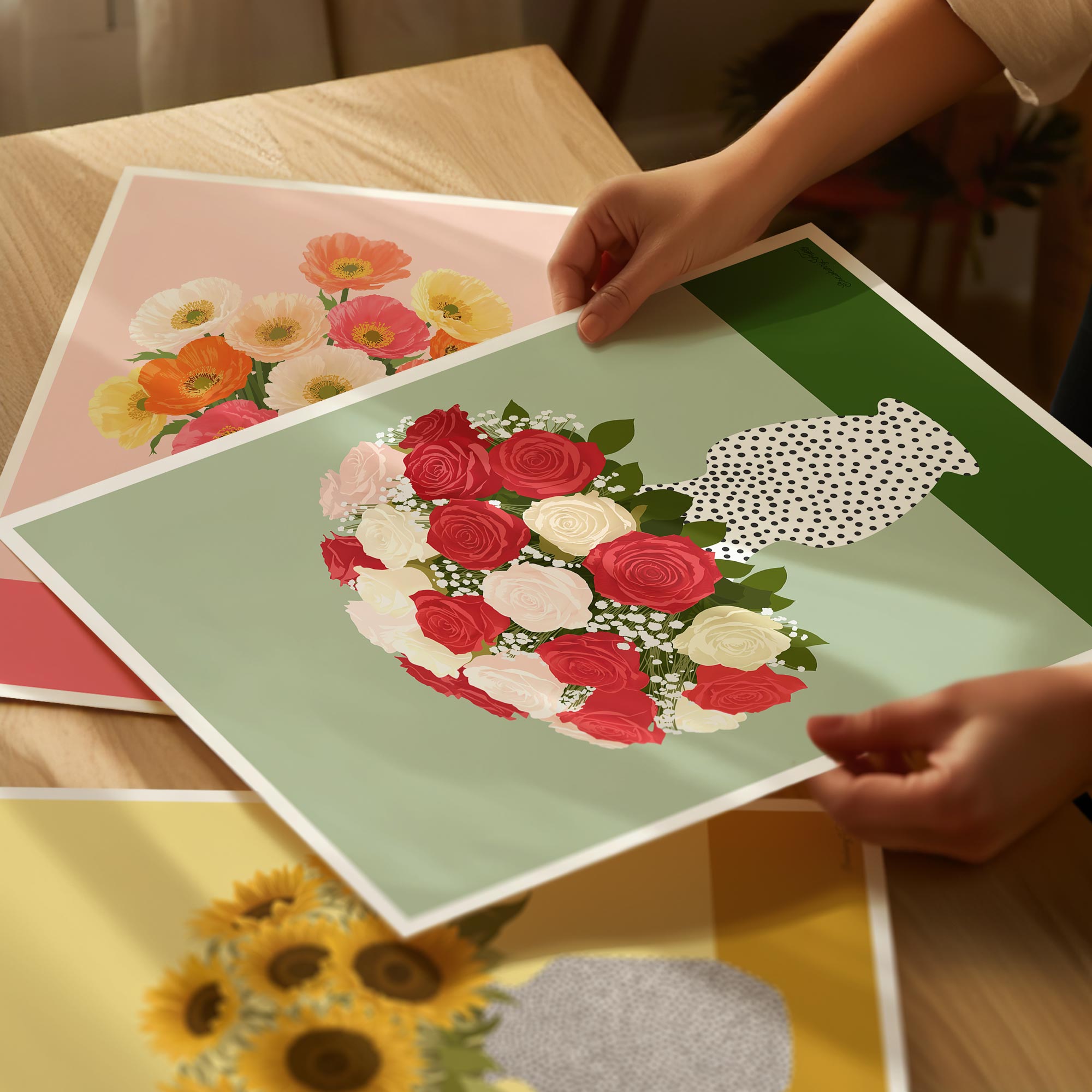 Person holding a card with a floral design on a wooden table