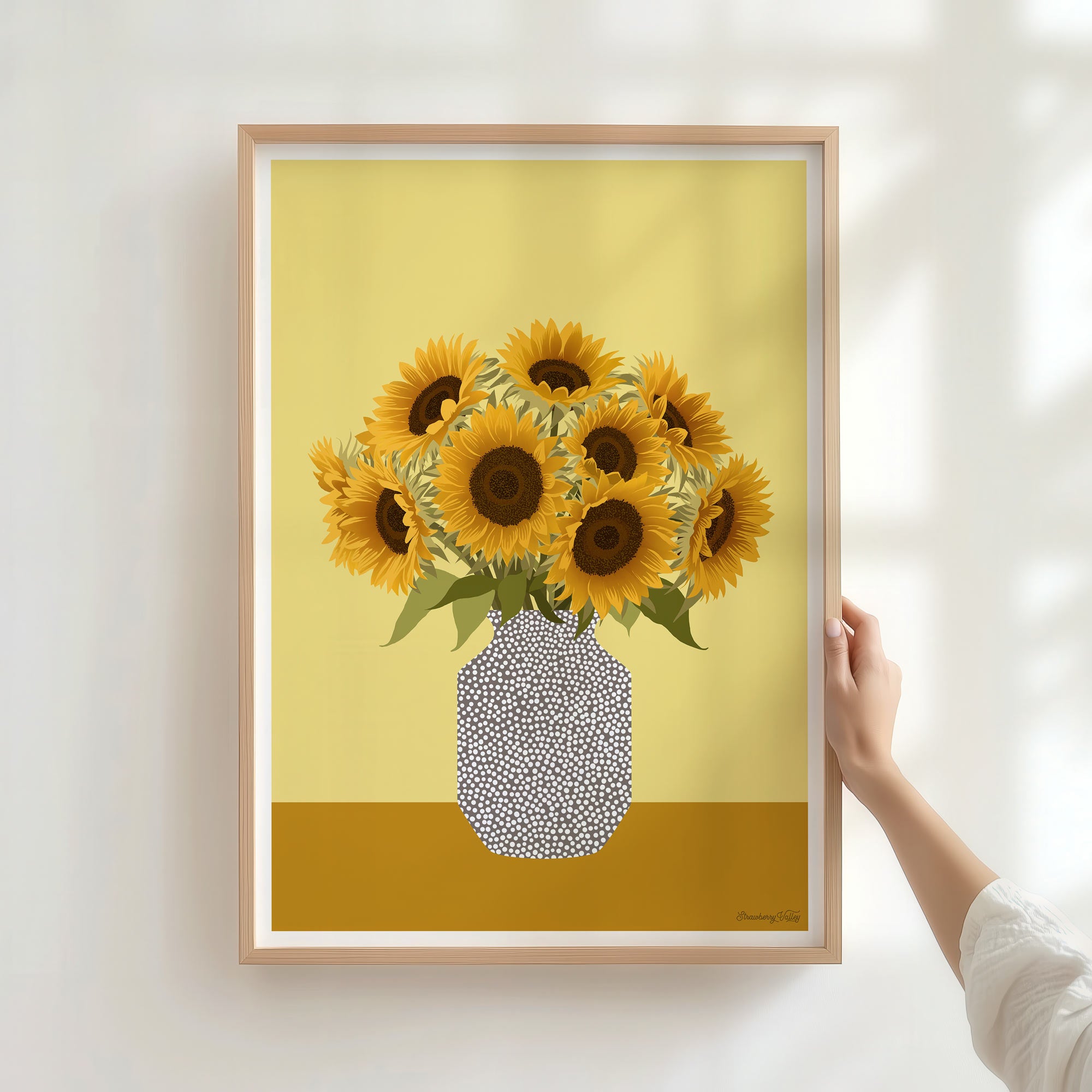 Framed artwork of sunflowers in a vase on a yellow background