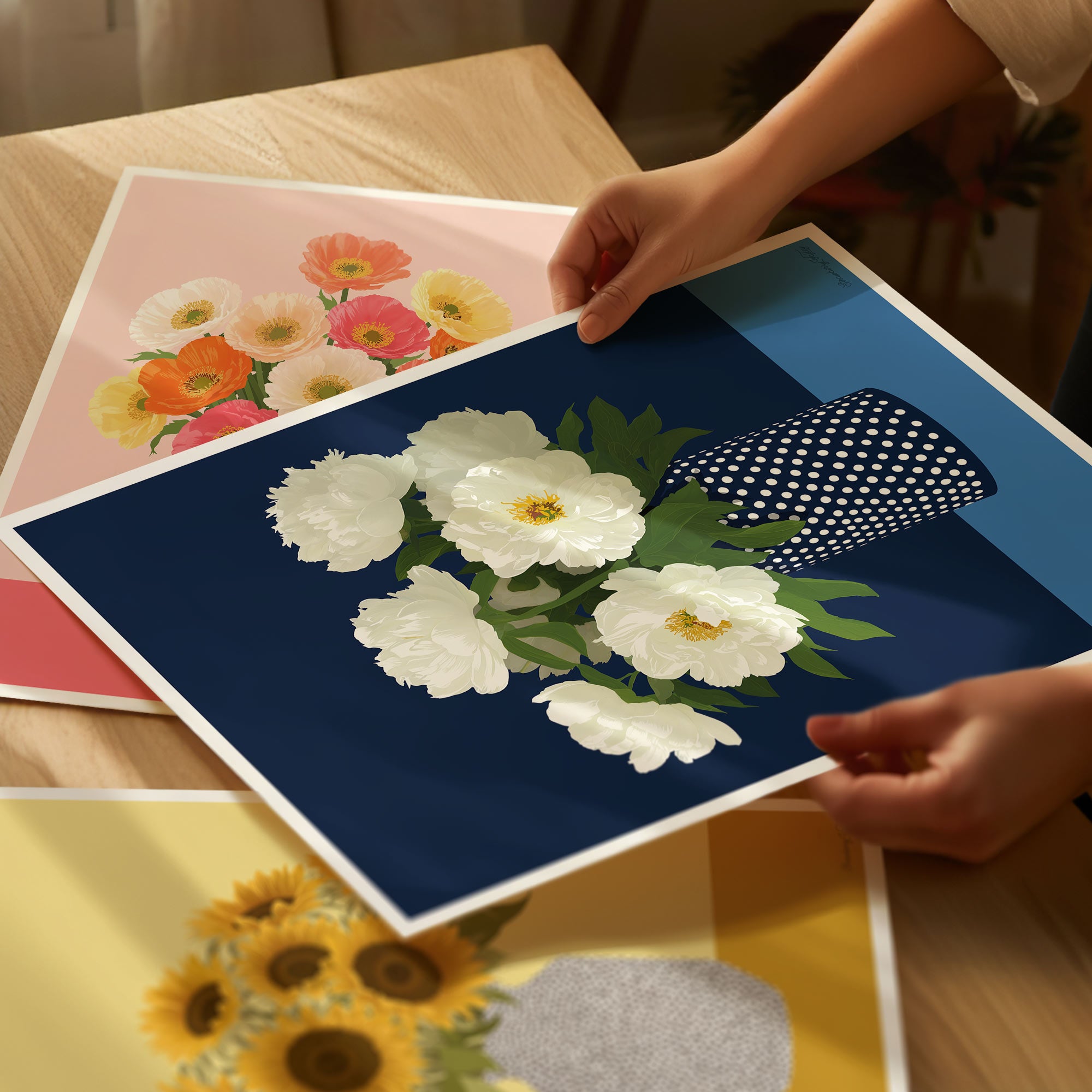 Person holding a floral print with white flowers on a blue background